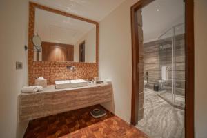 bagno con lavandino, specchio e doccia di The Kabo a Srinagar