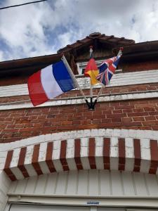 deux drapeaux sur le côté d'un bâtiment dans l'établissement 14-18 Somme Chambres, à Beaucourt-sur-lʼAncre