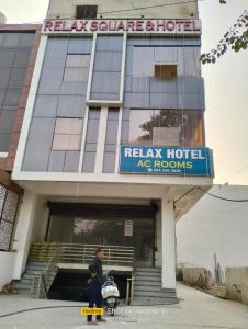 un hombre montando una patineta delante de un edificio en Relax Square & Hotel By WB Inn, en Alwar