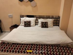 Una cama con dos almohadas encima. en Relax Square & Hotel By WB Inn, en Alwar