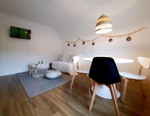 Rooms 6 persons Kaysersberg في كايزرسبرغ: غرفة معيشة مع طاولة وسرير