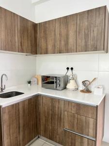 a kitchen with a sink and a microwave on a counter at Lily Ville in Tanah Rata