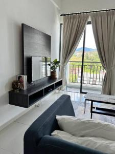 a living room with a blue couch and a large window at Lily Ville in Tanah Rata