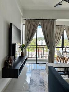 salon z kanapą i dużym oknem w obiekcie Lily Ville w mieście Tanah Rata