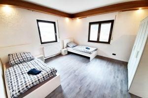 Habitación con 2 camas, sofá y 2 ventanas. en Work & Stay Apartments in Hönningen, en Hönningen