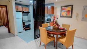 a kitchen and dining room with a table and chairs at Xclusive Hotel Apartments in Dubai