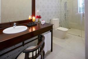 a bathroom with a sink and a toilet and a mirror at Ekho Lake House in Polonnaruwa