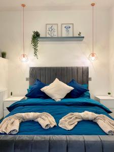 a blue bed with blue pillows and towels on it at Fidelity Stays Ocean Themed Luxury Apartment in Brighton & Hove