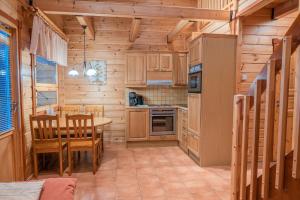 a kitchen with wooden cabinets and a table and chairs at Tahko-Tours Oy in Tahkovuori