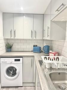 a kitchen with a washing machine and a sink at Fidelity Stays Ocean Themed Luxury Apartment in Brighton & Hove