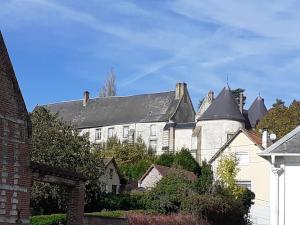 duży biały budynek z czarnym dachem w obiekcie 14-18 Somme Chambres w mieście Beaucourt-sur-lʼAncre