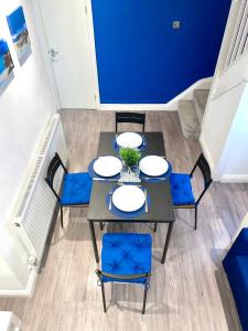 a dining room with blue walls and a table and chairs at Fidelity Stays Ocean Themed Luxury Apartment in Brighton & Hove