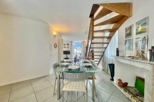 a dining room with a table and a staircase at Menaggio Fantastico in Menaggio