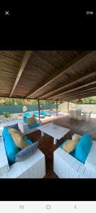 eine Terrasse mit weißen Sofas und blauen Kissen in der Unterkunft Magnifique villa à deux pas de St tropez in Cogolin