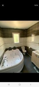 ein Badezimmer mit einer großen Badewanne und einem WC in der Unterkunft Magnifique villa à deux pas de St tropez in Cogolin