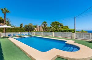 una piscina de agua azul en un patio en Villa Dorada - PlusHolidays, en Calpe