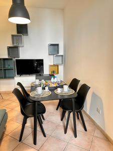 ein Esszimmer mit einem Tisch und schwarzen Stühlen in der Unterkunft Al centro storico Home in Salerno