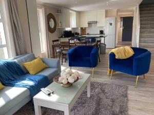 uma sala de estar com um sofá azul e uma mesa em Chapman`s Peak, Loft mit Sea-und Mountainview em Hout Bay