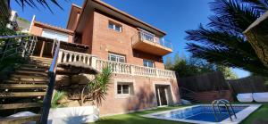 una casa de ladrillo con piscina frente a ella en Casa en Alella, Barcelona en Alella