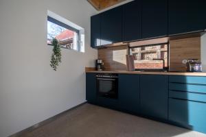 a kitchen with dark blue cabinets and a window at Modernes Ferien- und Messezimmer in idyllischer Lage in Nordstemmen