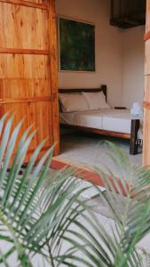 ein Schlafzimmer mit einem Bett und einer Pflanze in der Unterkunft Vila Corumbau Cacau in Corumbau