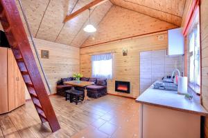 a kitchen and living room with a staircase in a log cabin at U Źródeł Strwiąża in Ustrzyki Dolne