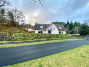 a house on the side of a road at The Beach House Loch Lomond in Luss