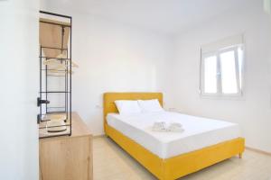 a bedroom with a white bed and a mirror at Asteria Apartments in Analipsi