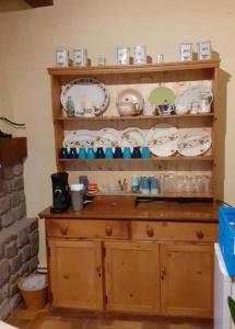 une étagère en bois avec des assiettes et de la vaisselle dans l'établissement 14-18 Somme Chambres, à Beaucourt-sur-lʼAncre