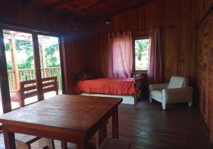 ein Schlafzimmer mit einem Bett und einem Tisch in einem Zimmer in der Unterkunft El Encanto. in El Soberbio