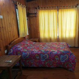 Schlafzimmer mit einem Bett und einem Holztisch in der Unterkunft El Encanto. in El Soberbio