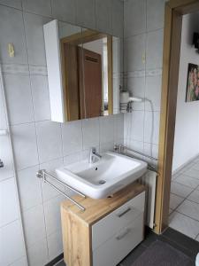 y baño con lavabo blanco y espejo. en Helle Ferienwohnung in Nettetal bei Venlo, en Nettetal