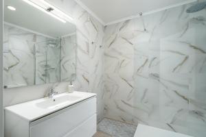 un bagno bianco con lavandino e specchio di Apartamento Algarve, located center of Vilamoura a Quarteira Altre 15 foto