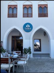 a restaurant with tables and chairs in front of a building at The Beach House in Muscat