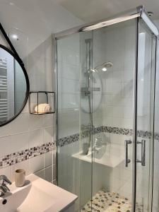 ein Bad mit einer Glasdusche und einem Waschbecken in der Unterkunft Appartement à louer, Bandol in Bandol