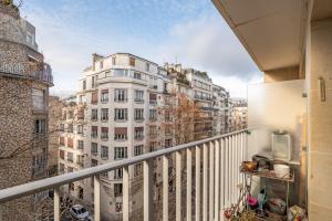 balkon z widokiem na wysoki biały budynek w obiekcie Veeve - Fragments in Time w Paryżu