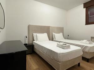 een slaapkamer met 2 bedden en handdoeken bij Due Carrare Business in Due Carrare