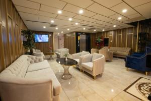 a living room with couches and a table and chairs at Leslion Luxury Hotel in Antalya