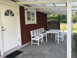 patio ze stołem, krzesłami i białymi drzwiami w obiekcie B & B Flattinge Fritidshus w mieście Vittaryd
