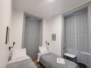 a bedroom with two beds and a window at Vila Santa Cruz Guest House in Braga