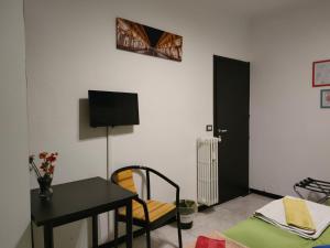 Habitación con mesa, escritorio, mesa y silla. en BB Torino Chicca Stadio Olimpico, en Turín