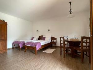 1 dormitorio con 1 cama, mesa y sillas en Kovács tanya - falusi szálláshely 