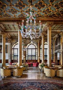 a large lobby with a chandelier and tables and chairs at Hotel Danieli, Venice in Venice