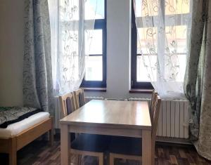 a table and chairs in a room with windows at Penzion a wellness U Třeboňské madony in Třeboň