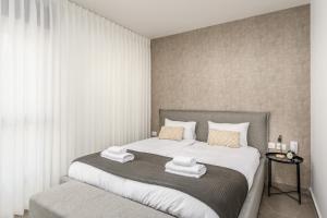 a bedroom with a bed with two towels on it at prestige 2BDR&2Bth w Parking- mahne yehuda sea-u jerusalem in Jerusalem