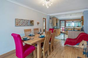 a dining room and kitchen with a wooden table and chairs at 40 Church Street in Aberffraw