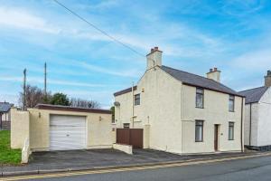 a large white brick house with a garage at 40 Church Street in Aberffraw