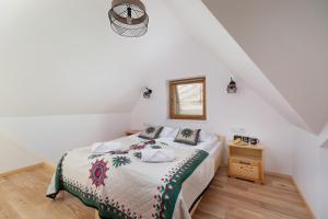 una camera bianca con letto e pavimento in legno di GiewontView Two-Story Apartment by Renters Prestige a Kościelisko