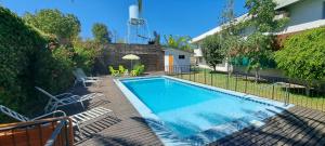 a swimming pool in a yard with chairs and a fence at Hotel Los Andes in Los Andes