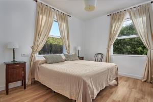 a bedroom with a bed and two large windows at Las Sabinas Playa - El Guincho, Garachico in Garachico